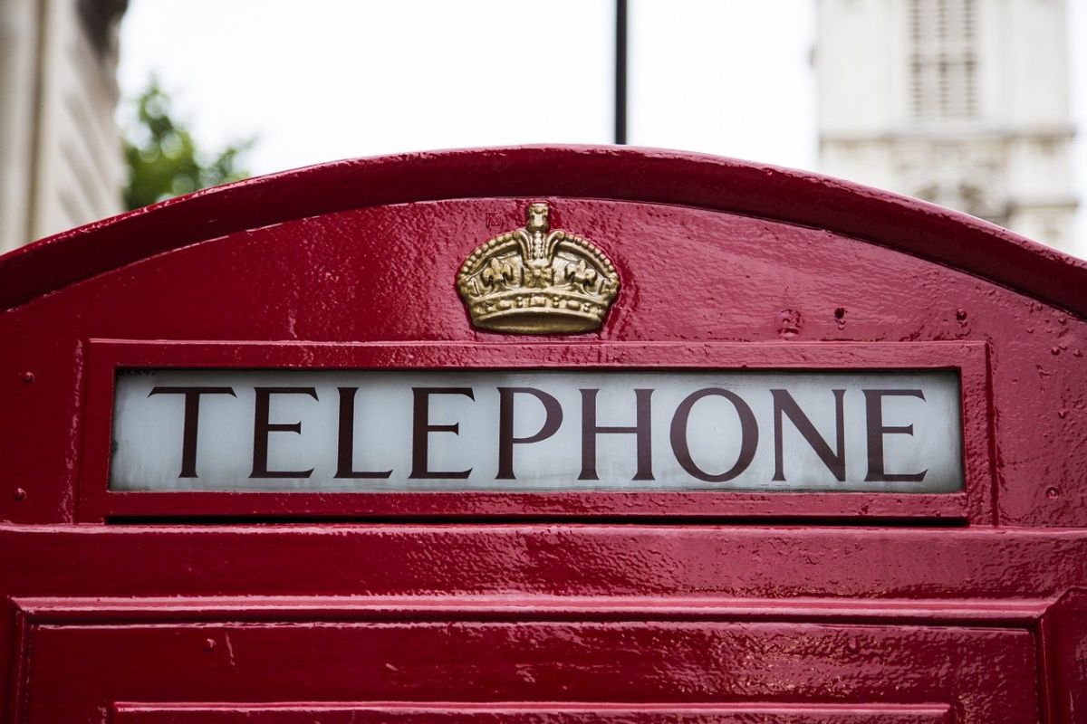 prim plan cu partea de sus a unei cabine telefonice traditionale rosii din Londra folosita pentru a comunica in engleza