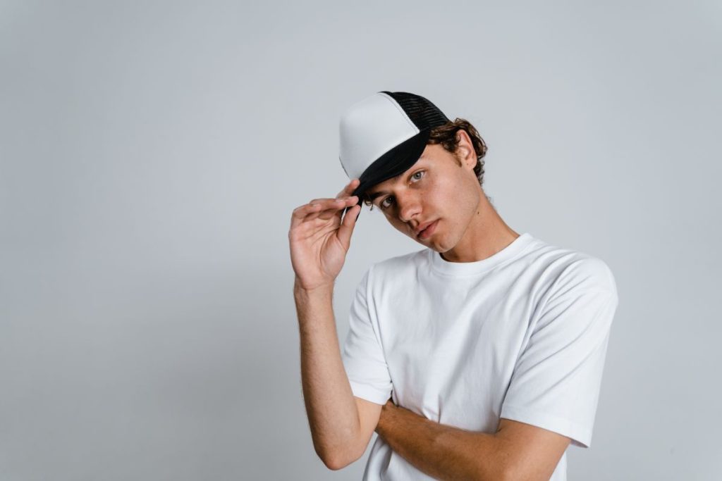 Adolescent cret in tricou alb cu sapca pe cap 