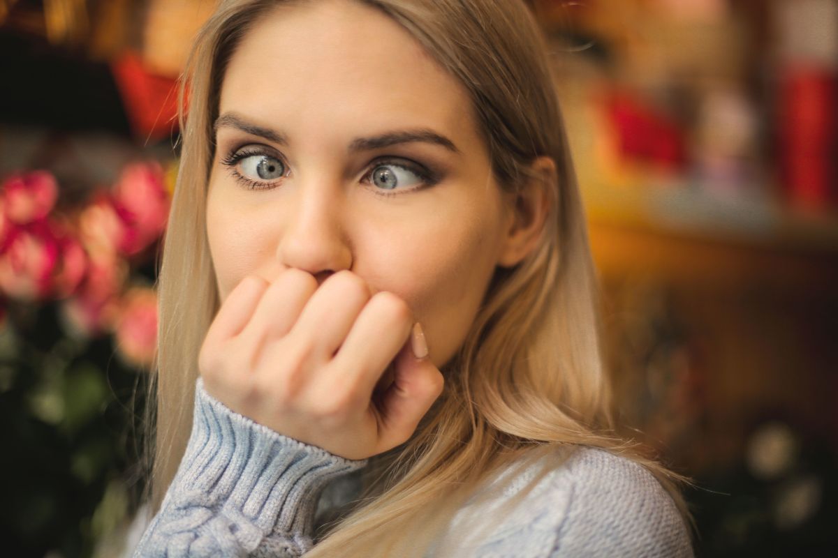 femeie blonda cu parul lung si pulover bleu se uita crucis pentru ca e ametita