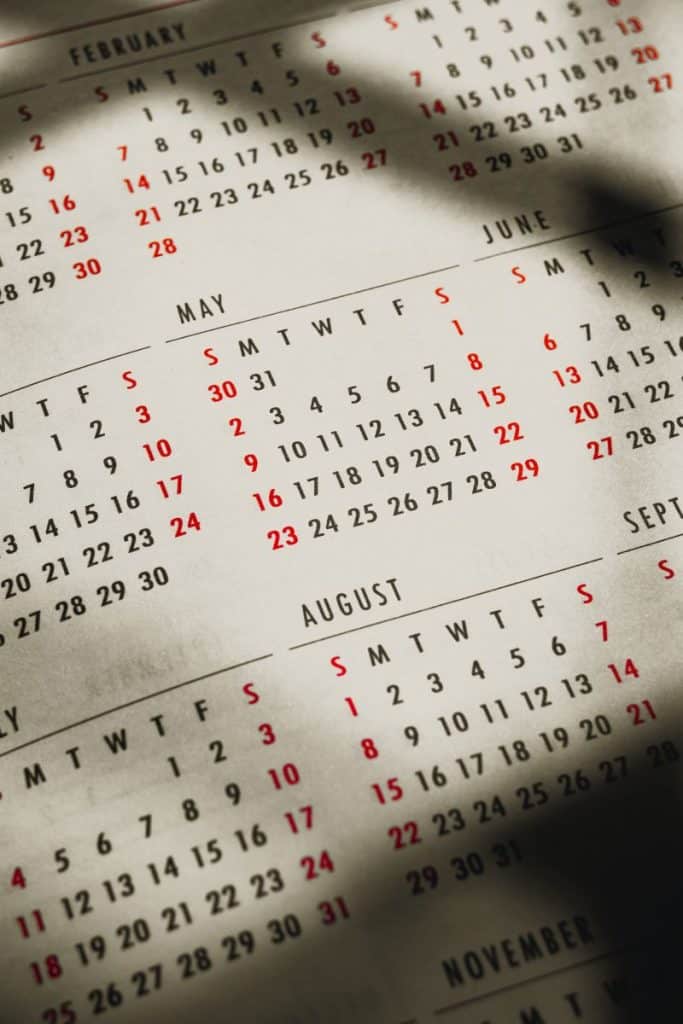 prim plan pe calendar in engleza alb negru cu zilele de duminica scrise cu rosu