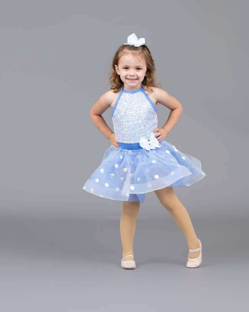 Fetita de trei ani imbracat in rochita de balet albastra cu argintiu si balerini si cu funda alba pe cap