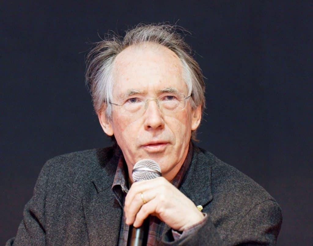 autorul britannic ian Mcewan imbracat in camasa si sacou gri vorbeste la microfon avand in spate fundal negru