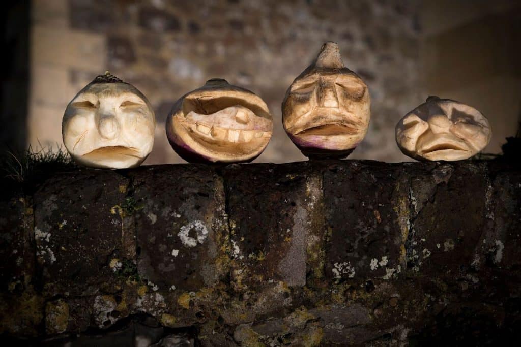 patru napi pe o bordura sculptati cu fete infricosatoare