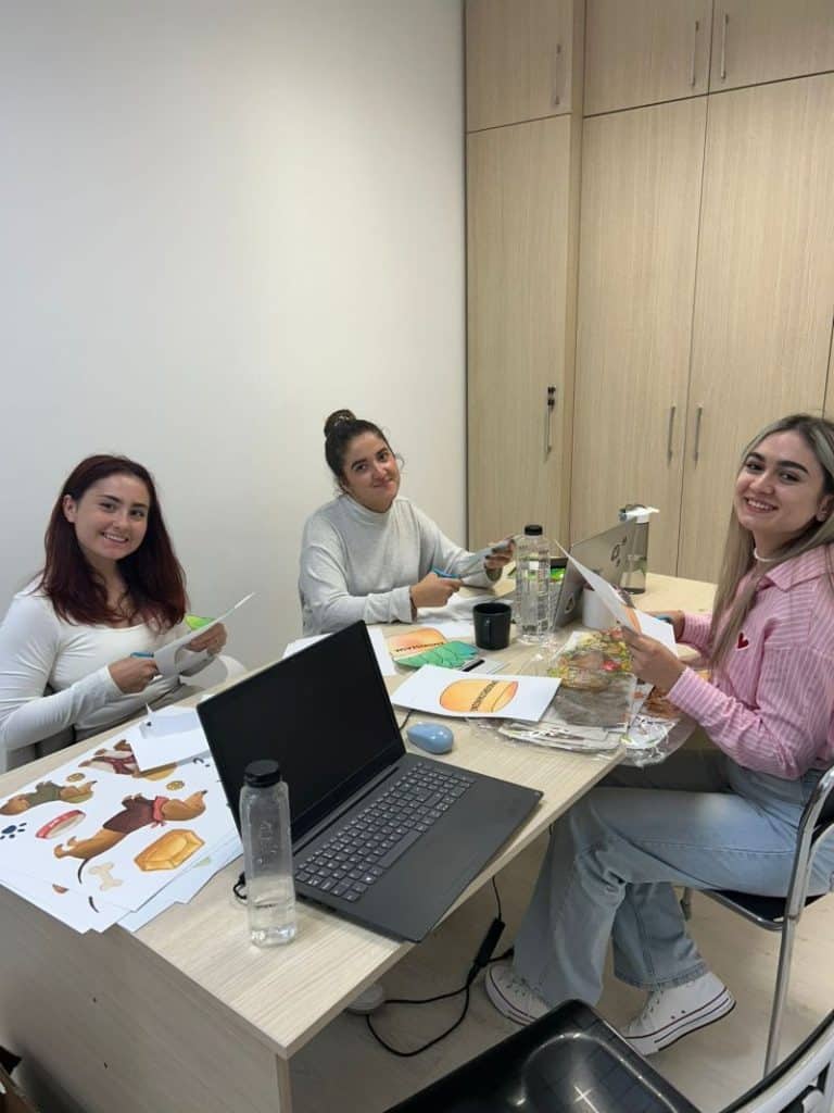 Profesoare FollowMe care decupeaza materiale pentru un proiect cu copiii.